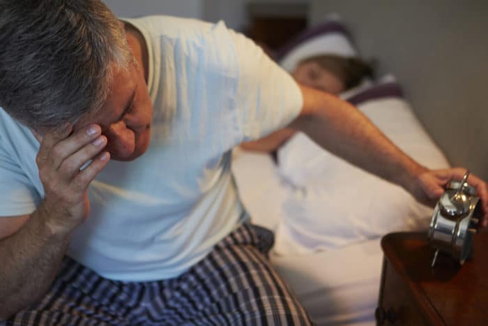 Insomnia: awake and miserable, unable to get quality sleep What is insomnia? Man awake In bed unable to sleep at night.