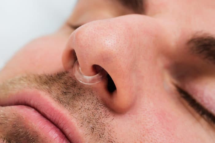 Man with anti-snoring device in nose