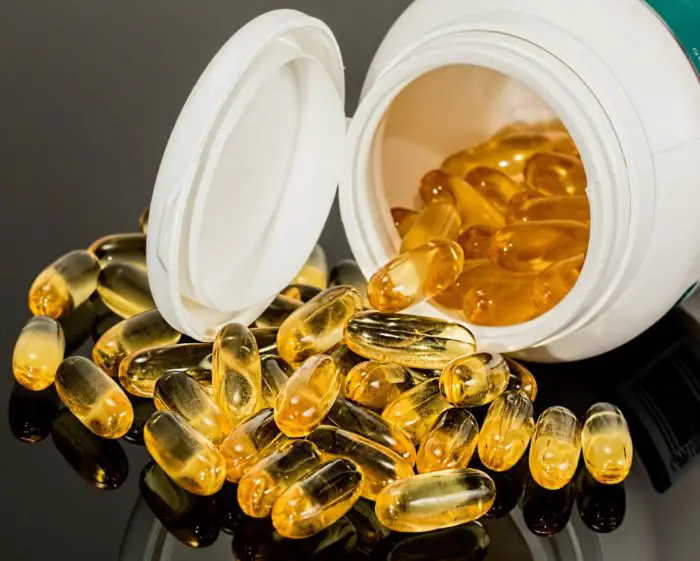 picture of natural supplement capsules spilling out of bottle