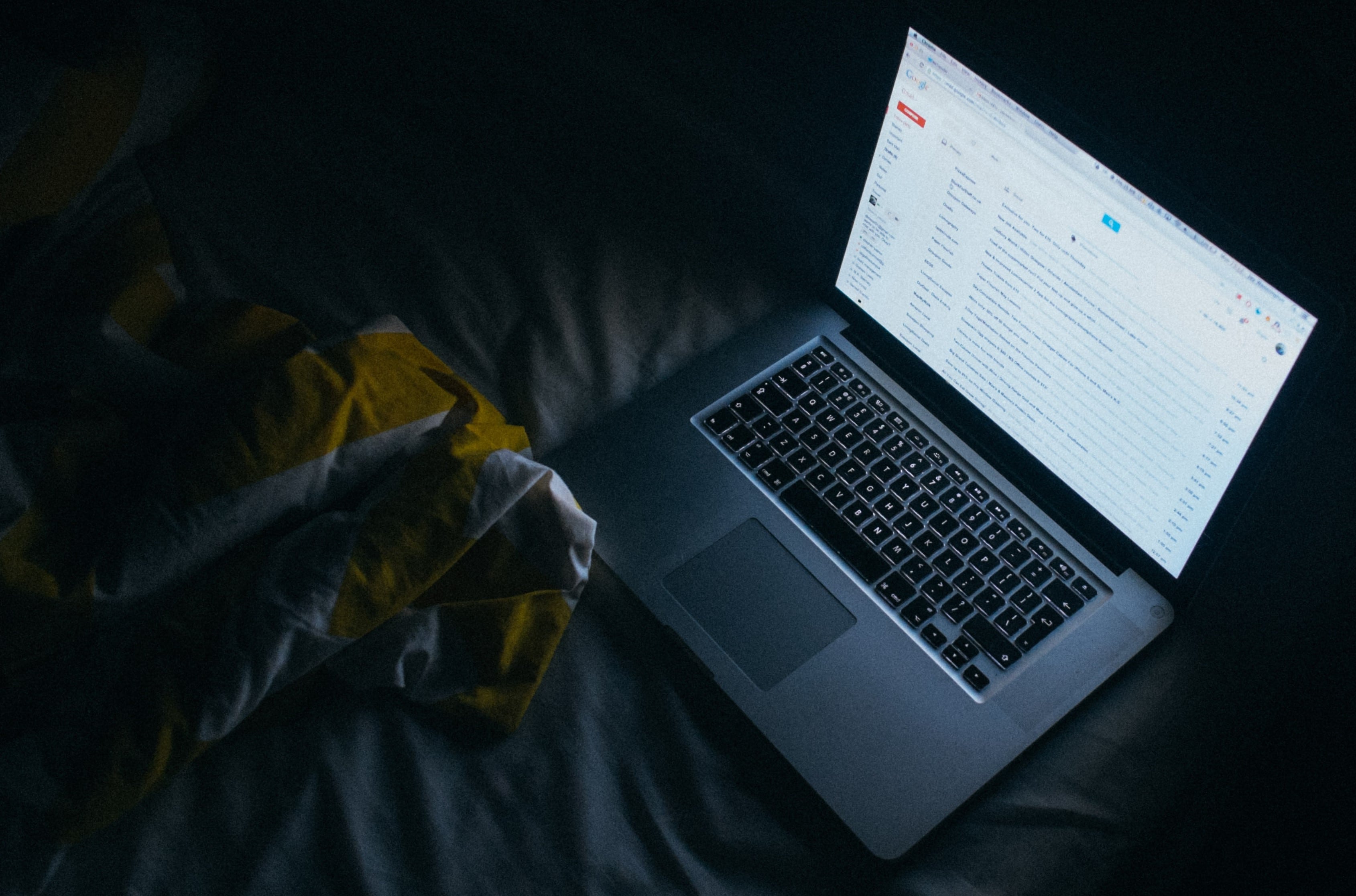 Many people use blue light blocking glasses for protection in the evening from electronic devices such as this laptop laptop on a bed in the evening emitting harmful bright light that blue light blocking glasses can be used for protection