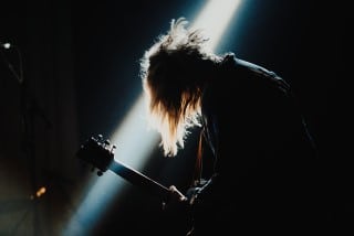 Avoid loud and heart racing music - it won’t help you fall asleep Picture of musician at rock music concert