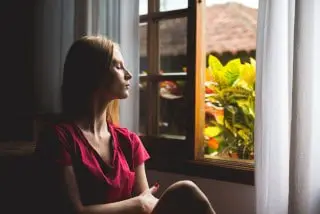 picture of lady meditating by the window for pain management