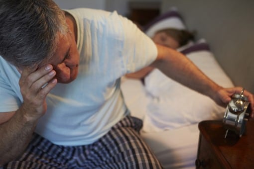 man at risk for diabetes wide awake in bed fighting insomnia