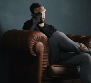 Dealing with sleep apnea and daytime panic attacks at the same time can leave you feeling exhausted and miserable man overwhelmed with sleep apnea and daytime panic attacks sitting on couch