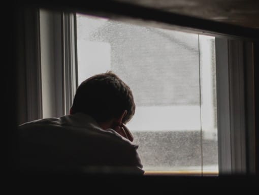 man overwhelmed with sleep apnea and daytime panic attacks looking out the window