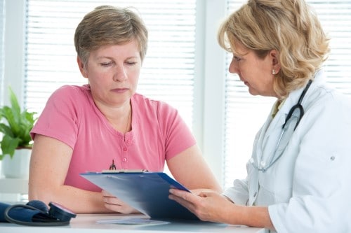 photo of lady talking to doctor because she’s sleeping poorly and worried snoring may lead to a divorce