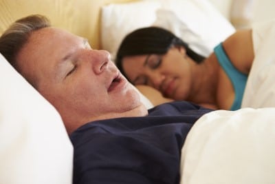 Man snoring at night which will cause a sore throat