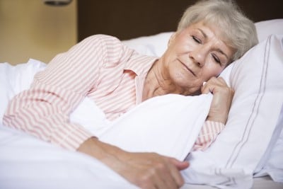 lady sleeping on her side to prevent snoring and sore throats