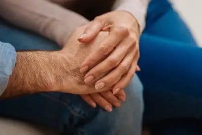 It’s important to be honest if your spouse keeps the TV on at night photo of couple holding hands who are struggling with one keeping the TV on at night