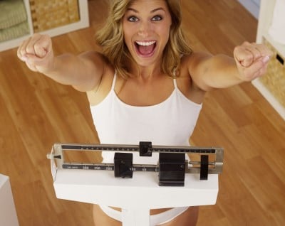 photo of lady on weigh scale who’s happy she’s lost weight