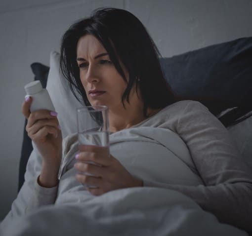 Women awake in bed worried her pain meds are keeping her awake