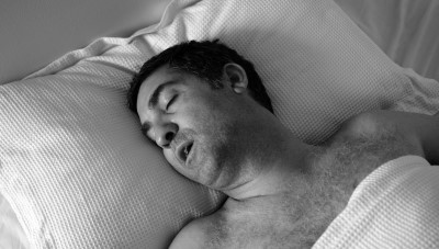 man with sleep apnea snoring in bed