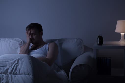 picture of miserable man showing what happens if shoulder pain is keeping you from sleeping on your side