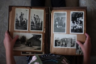 picture of person looking at photo album which is something you can do when bored in bed at night