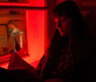 photo of  lady reading a book instead of beer before bed