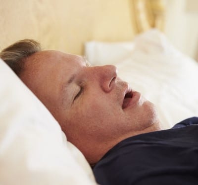 picture of man sleeping on his back which you should avoid if you’re trying to treat sleep apnea yourself