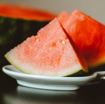 watermelon slices on table which is to be avoided when too hungry to sleep