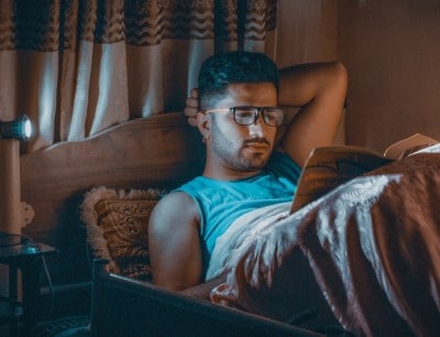 young sitting up in bed who can’t stop reading before bedtime