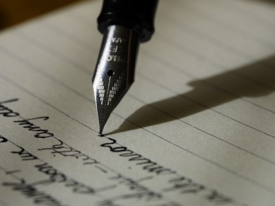 photo of pen being used to write on paper