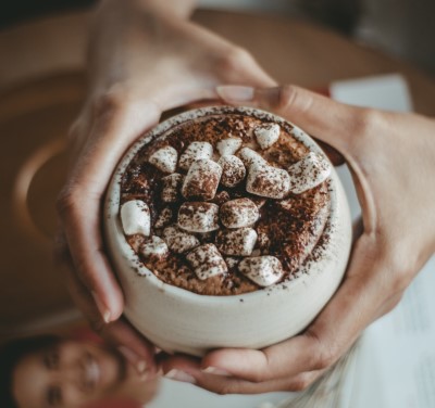 photo of holding cup to drink their hot chocolate before bed with marshmallows