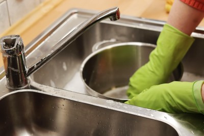 photo of person washing dishes late at night because they’re too excited to sleep