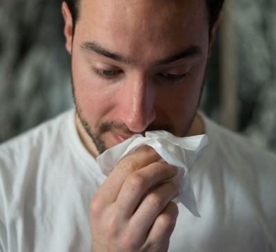 photo of man with runny nose from allergies he suspects is from bedroom plants