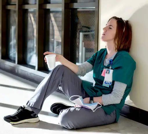 All too many nurses and health care provides are struggling with sleep photo of tired nurse resting in hallway at work