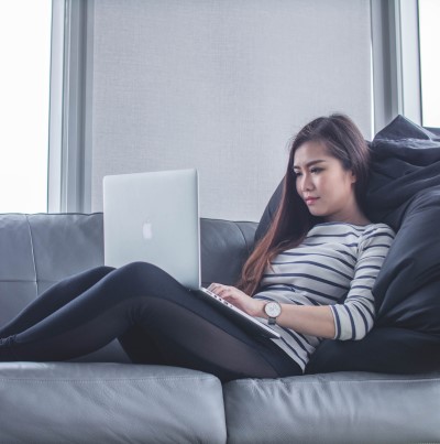 photo of lady of couch with laptop computer