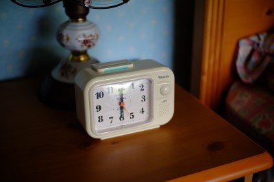  photo showing alarm clock on bedstand