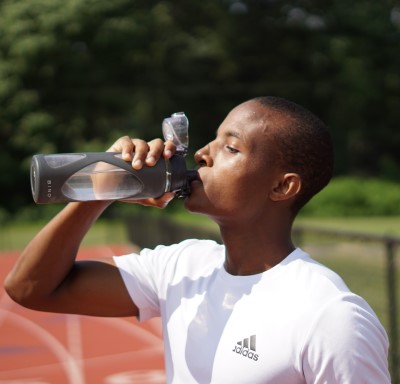 photo of man drinking water during workout