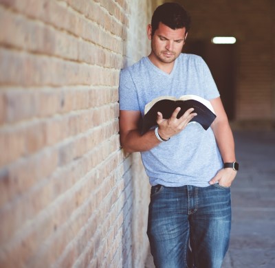 photo of man standing to stretch his legs to help him stay awake at church 