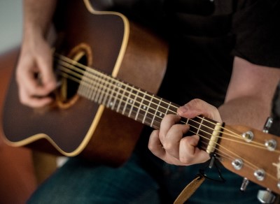  photo of man playing his guitar as a fun thing to do before bed