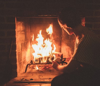   photo of lady watching the fire place as a fun thing to do before bed