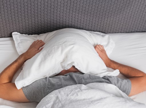 You’re not the only one too stressed about grades to sleep Photo of male wide awake in bed because he’s too stressed about grades to sleep