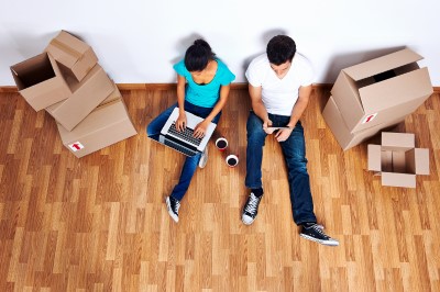 photo of couple up late in room with unpacked boxes who can’t sleep after moving