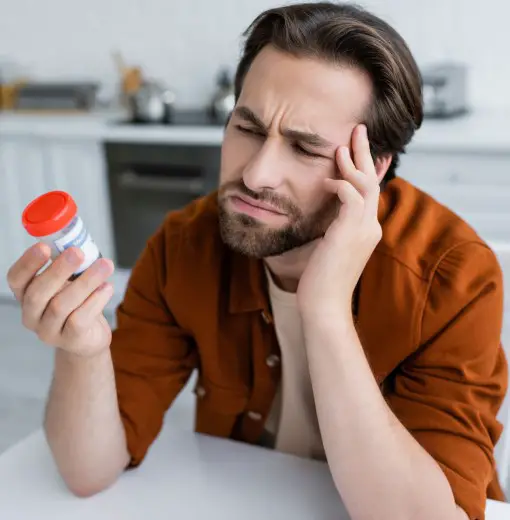 photo of man reading bottle to check if ok to take CBD with sleeping pills 