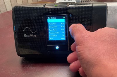 Humidity can make a difference for CPAP users fighting allergies photo showing person adjusting CPAP machine settings to help with allergies
