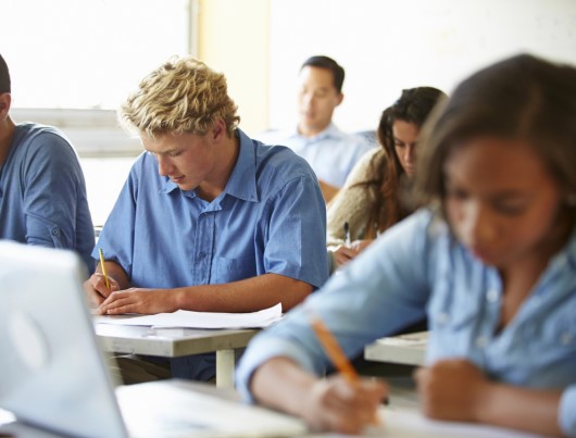 photo of tired teen students taking a test