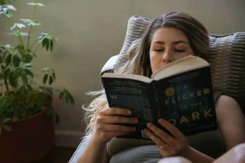 Spending more time inside can help photo of woman reading inside during the day