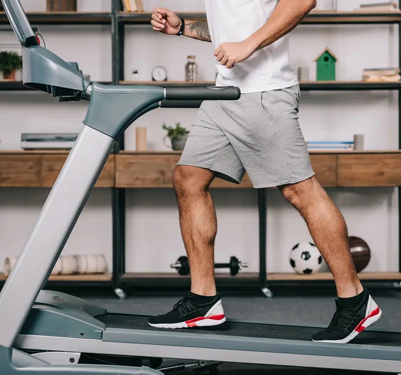man using the extra hour from the fall daylight savings time change to work out on a treadmill